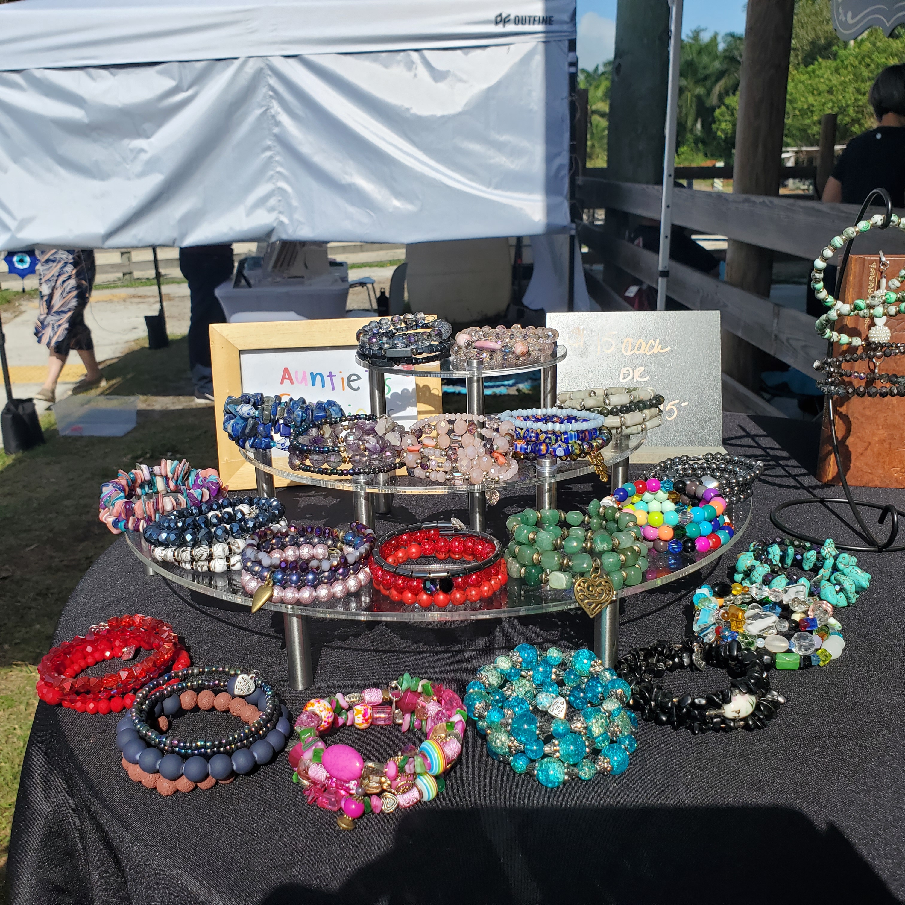 a display of various bead bracelets on a three-tiered tray