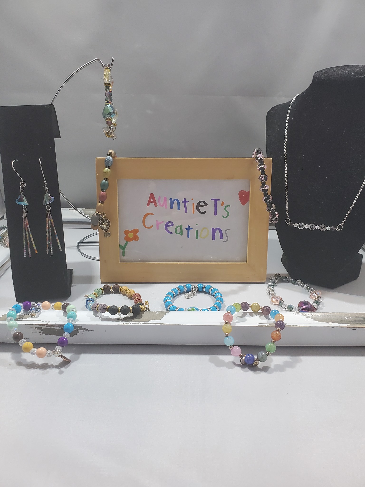 an Auntie T's creations sign surrounded by various bead jewelry
